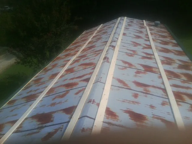 Rusted metal roof panels with new wood purlins before replacement — Storm Damage Roof Repair in Kaysville by Roofing Brothers