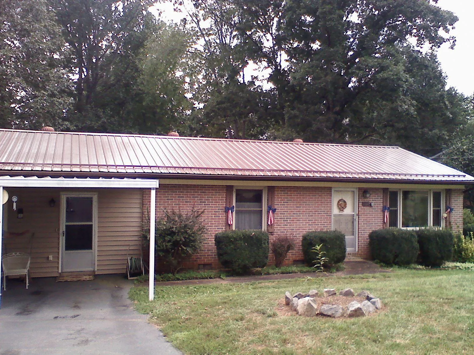 Bronze metal roof and carport on a brick ranch home — Roof Repair work by our crew in Kaysville